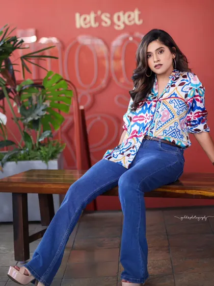 A lifestyle fashion shoot for an actress, featuring a colorful printed shirt and blue jeans. Shot in a modern cafe, these images have a bright, energetic, and youthful feel, perfect for a commercial or social media campaign.