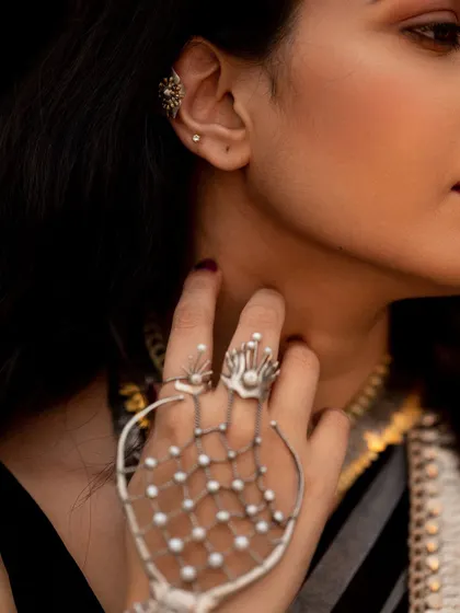 A detail shot of the unique hand harness and ear cuff. Highlighting these details is key for fashion and jewelry photography.