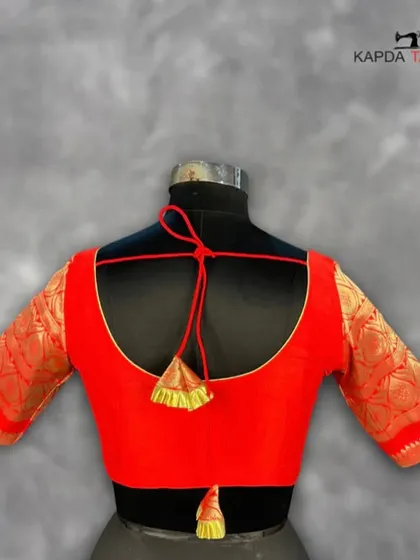 This deep red brocade blouse is a statement of elegance. The rich texture of the fabric and the classic U-back with a dori tie make it a sophisticated choice for any wedding or festive event.