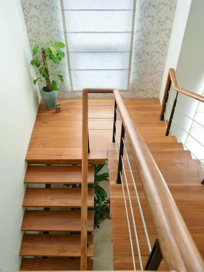 The wooden landing and steps of the staircase create a warm and inviting transition between floors.
