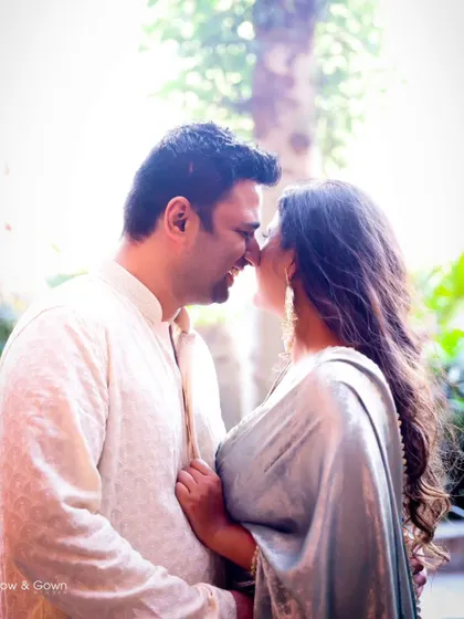 A romantic, sun-flared shot from a Roka ceremony. The couple is sharing an intimate nose-to-nose moment, creating a dreamy and beautiful image.