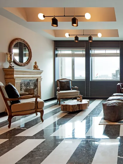 We believe in designing the 'in-between' spaces with intention. This living room, with its bold striped marble floor and classic fireplace, is designed as a formal yet comfortable area for receiving guests.