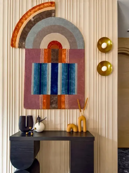 Wall art is a powerful tool for storytelling in a space. This colorful, abstract piece acts as a focal point in the lobby, introducing a palette of warm and cool tones that are echoed in other decor elements. It brings energy and a touch of bohemian charm to the entrance.
