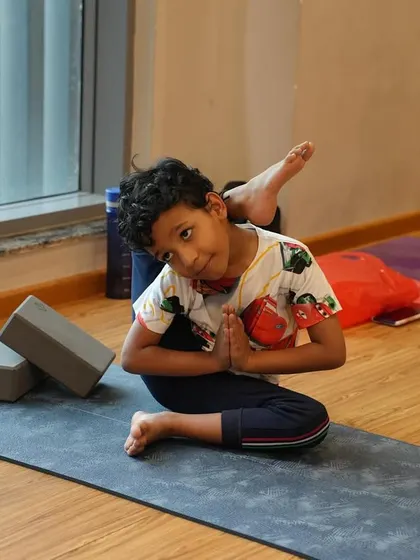 This young yogi shows amazing focus and hip flexibility in this seated twisting pose. It's a complex asana that he approaches with a calm and playful spirit.