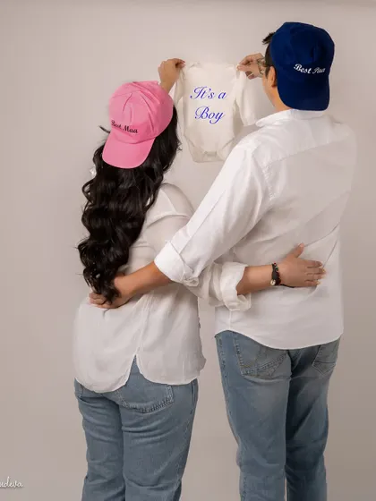 A fun and cute gender reveal. The "Best Mom" and "Best Dad" hats with the "It's a Boy" onesie are a sweet and personal touch for a casual shoot.
