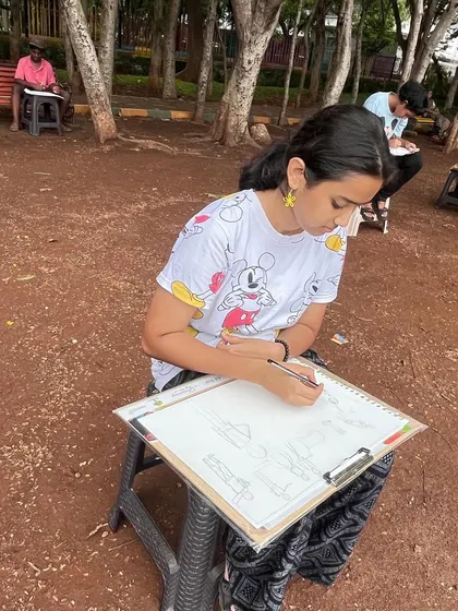 A student works on her human figure sketches during our outdoor session. The goal is to quickly capture the posture and movement of people in the park.