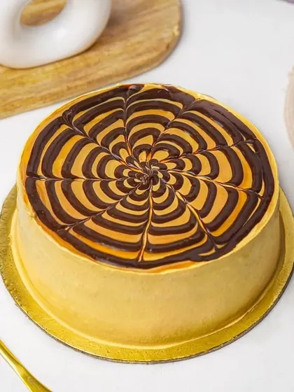 A top-down view of a butterscotch cake, highlighting the beautiful and intricate glaze design.