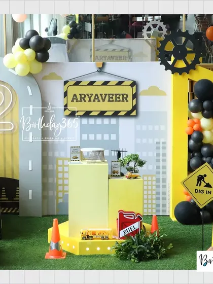 The main stage for Aryaveer's construction party, featuring a personalized name sign, a light-up number "2", and various construction-themed props.