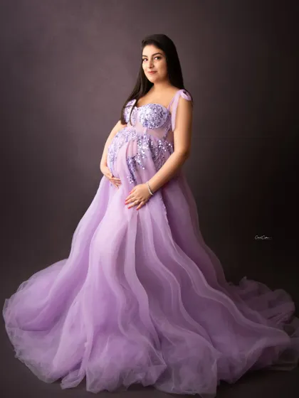 This gorgeous mama glows in a lavender tulle gown with intricate silver embroidery on the bodice, holding her bump with such tenderness.