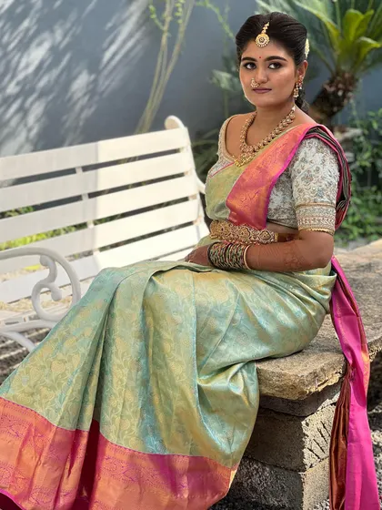 A full-length shot of the bride seated, looking serene and elegant. The makeup is balanced to look perfect from any distance.
