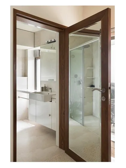 A view from the bedroom into the ensuite bathroom, showing how we use mirrored doors and consistent wood framing to create a sense of continuity and expand the space visually.