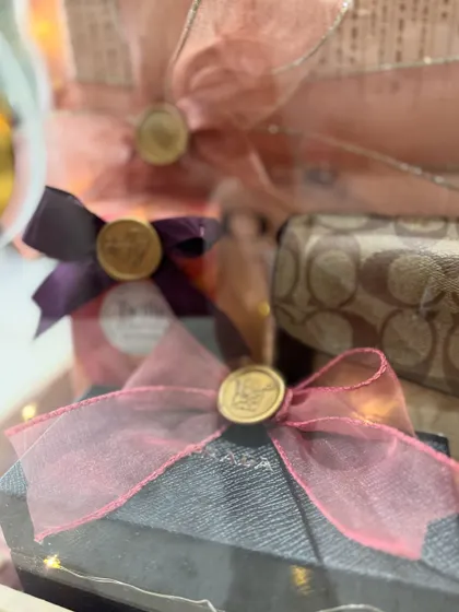 The beauty is in the details. This close-up shows the delicate organza ribbons and custom wax seals on individual gifts within the trousseau box.