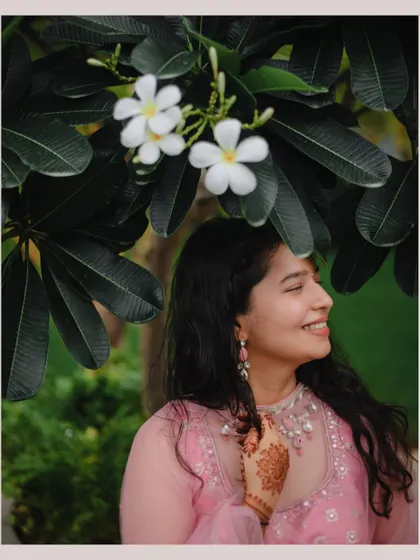 A beautiful, happy portrait of the bride from the Roka ceremony, her smile framed by lovely white flowers.