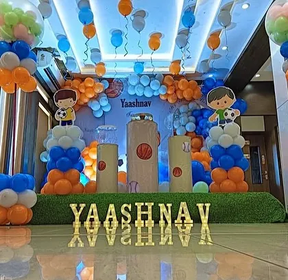 A wider view of the sports-themed birthday stage, showing the ceiling decoration with hanging balloons.