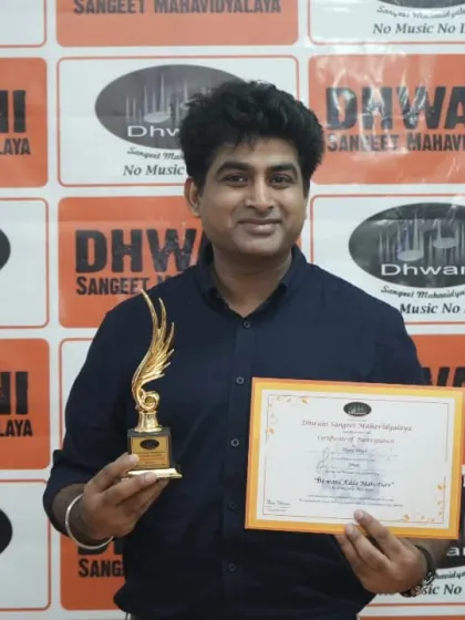 A student proudly holds his certificate and trophy.