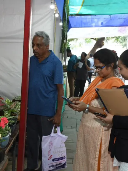 A visitor carefully inspects the plants on offer. We attract a discerning crowd of passionate gardeners and curious beginners alike.