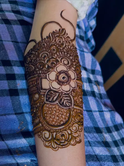 A close-up of the armband for Bride Rumana. The design features a large, beautiful flower as the centerpiece.