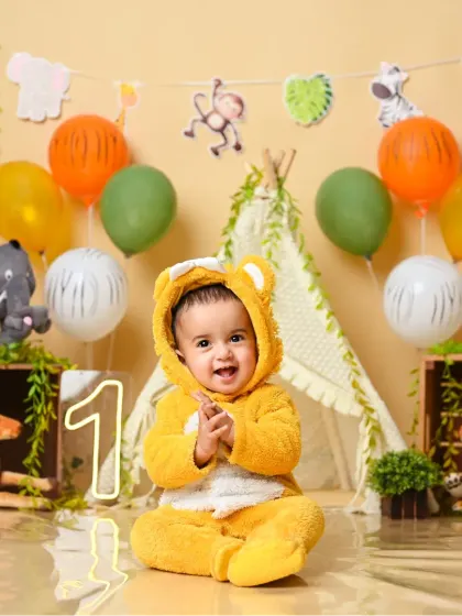 Roar! This little one is dressed as the cutest lion for his jungle-themed first birthday party.