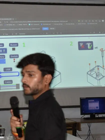 An instructor explains the assembly diagram for a robotics project during a workshop, guiding students step-by-step through the building process.