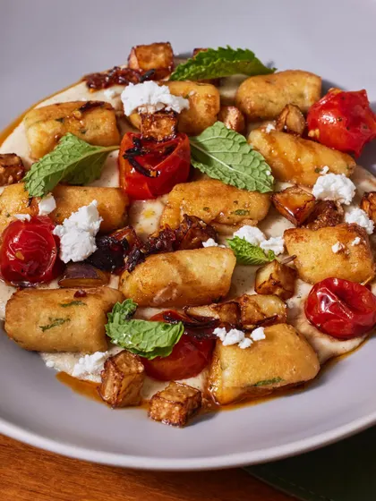 For our vegetarian guests, this pan-seared gnocchi offers a unique twist. The soft potato dumplings are paired with a smoky eggplant kashk, fresh mint, sweet blistered cherry tomatoes, and salty feta cheese.