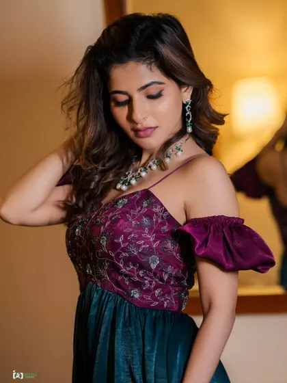 A soft, romantic glamour shot. The off-the-shoulder dress and the subject's gentle expression create a delicate and beautiful portrait, with the mirror reflection adding depth.