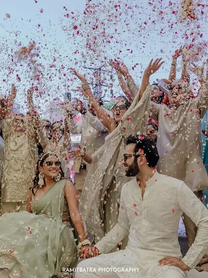 A candid moment of celebration as guests shower the couple with petals at their Fairmont Jaipur wedding.