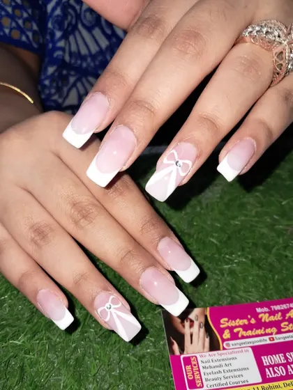 A classic French manicure on long square nails with a delicate, hand-painted white bow and a single rhinestone for a touch of simple elegance.