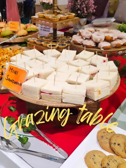 A beautiful grazing table setup for a watch launch party at a shopping mall. This spread includes mini sandwiches, cookies, and other finger foods, perfect for guests to mingle and snack.