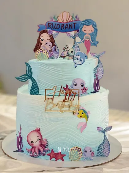 A vibrant and colorful two-tier mermaid cake. This one is covered in cute under-the-sea characters like octopuses and fish, perfect for a fun-filled birthday party.