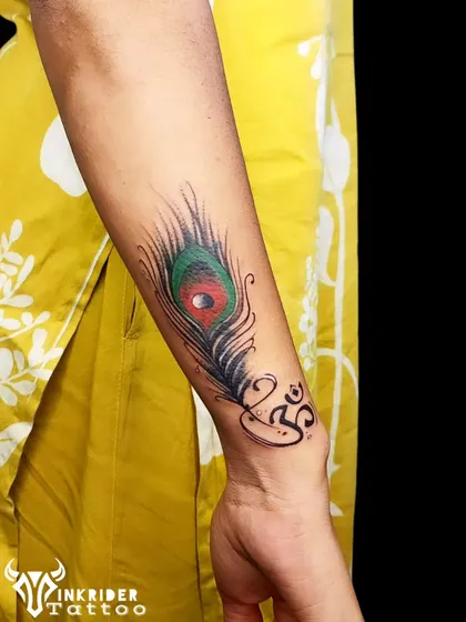 This piece was created to cover and correct a previous tattoo on the wrist. We used a colorful peacock feather design combined with a cleanly executed Om symbol to give the client a fresh, spiritual tattoo.