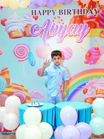 Avyay gives a peace sign at his awesome candy-themed party. The setup provides a fantastic background for capturing these happy, candid moments.
