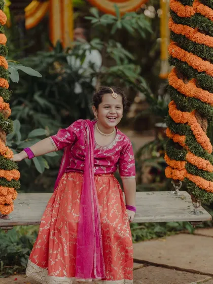 A young guest has a joyful moment on the floral oonjal, a favorite attraction for all ages.