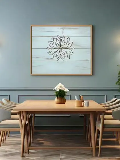 A simple and serene dining space. The light wood table and chairs are complemented by a calming blue-grey wall and minimalist pendant lighting.