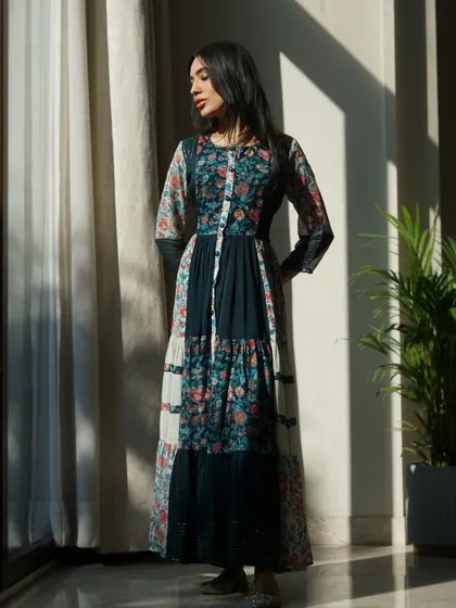 A full-length shot of a patchwork-style Anarkali dress, using natural window light to create soft shadows and highlight the various prints.