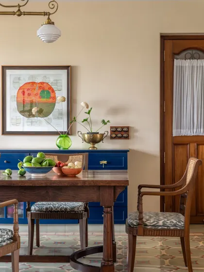 The dining area of the Calcutta home, where a bold blue console adds a pop of color. The space is a mix of vintage finds and modern pieces, reflecting a family that honors its past while living fully in the present.
