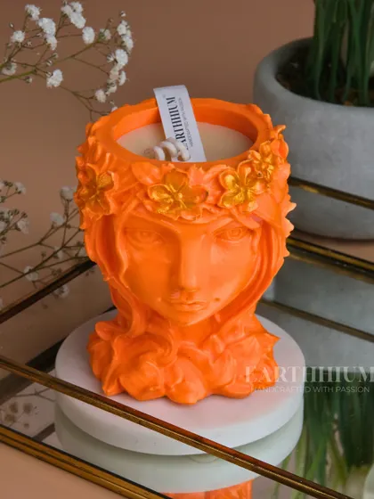 A vibrant orange candle poured into one of my sculpted Jesmonite figurine holders. This piece doubles as a candle and a striking piece of decor.