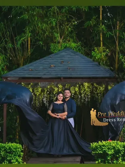 This couple opted for a coordinated look with a black trail gown. The man's dark shirt and light pants complement the gown, creating a chic and understated style.