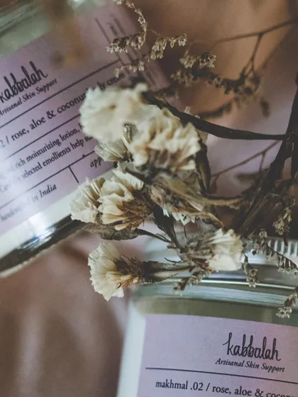 A beautifully styled shot of my 'Makhmal' lotion jars. The purple label and dried flowers hint at the calming, botanical ingredients inside.