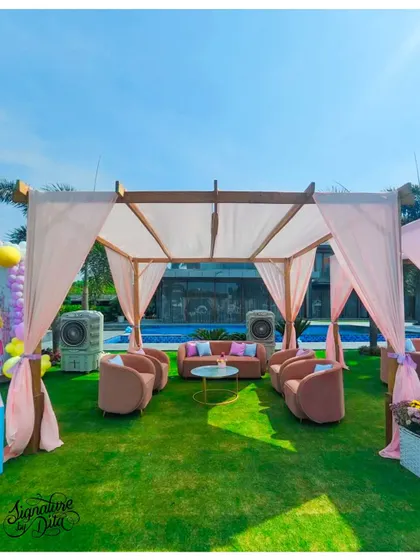 A pastel 'Disneyland' theme featuring a chic pink lounge setup under a poolside cabana.