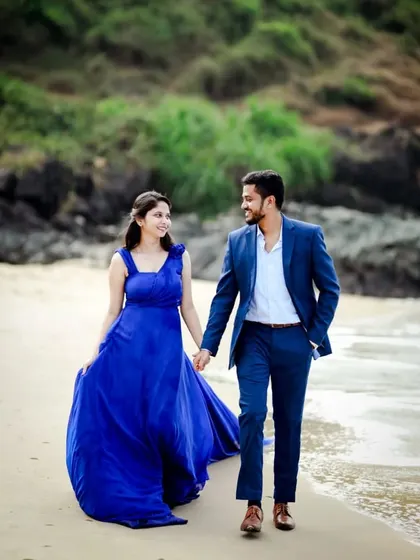 A candid shot of the couple walking on the beach. Her simple blue gown is perfect for a relaxed yet beautiful pre-wedding photoshoot by the water.