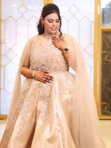 The bride looking down gracefully, a pose that highlights her necklace and the soft contours of her makeup.