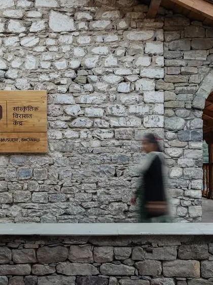 The museum's main entrance, with its clean wooden signage against the rustic stone wall, creates a welcoming and historically sensitive point of arrival.