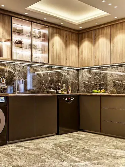 A luxurious kitchen with dark marble backsplash, wood-grain cabinets, and integrated laundry and dishwasher units.