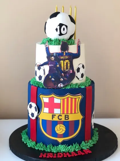 A two-tiered FC Barcelona cake for a Messi fan, featuring the team's colors and logo.