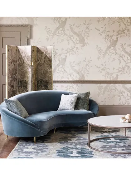 The 'Darnley' wallpaper features subtle bird motifs and metallic hints for a look of understated glamour. It's an ideal choice for a living room where elegance and tranquility are key.