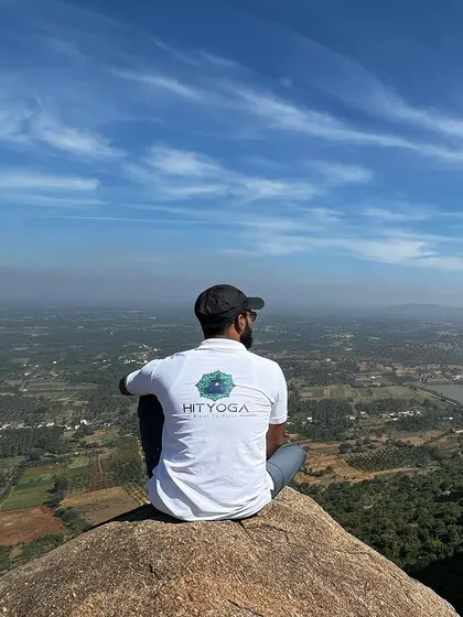 Overlooking a vast landscape from a mountain top, wearing my HITYOGA shirt.