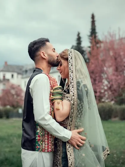 A tender forehead kiss during an outdoor wedding ceremony. This shot captures the love and commitment between the couple.