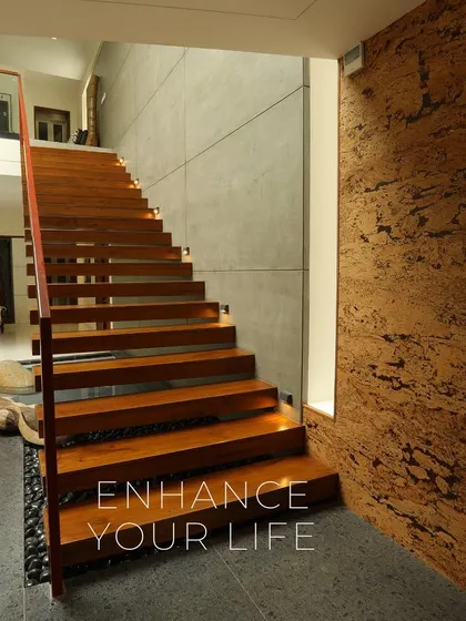 The staircase is more than just functional; it's a central design feature. Here, we combined the warmth of solid wood treads with the raw texture of concrete and cork walls, with integrated lighting to highlight the material interplay.