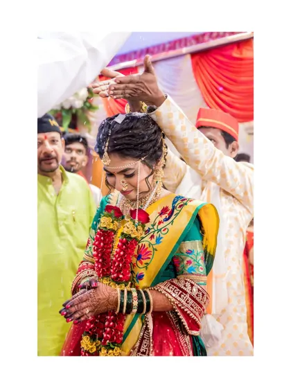 A beautiful shot of the bride being blessed with sacred rice during the wedding ceremony.