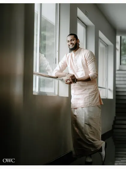 A handsome portrait of the groom looking out a window, captured in a moment of quiet reflection.